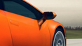 A close up of the side of an orange car