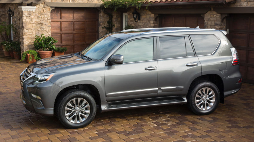 A silver suv parked in front of a brick building.