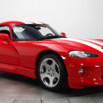 A red sports car with white stripes on the hood.