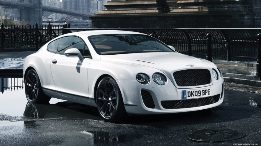 A white bentley continental gt is parked on the street.