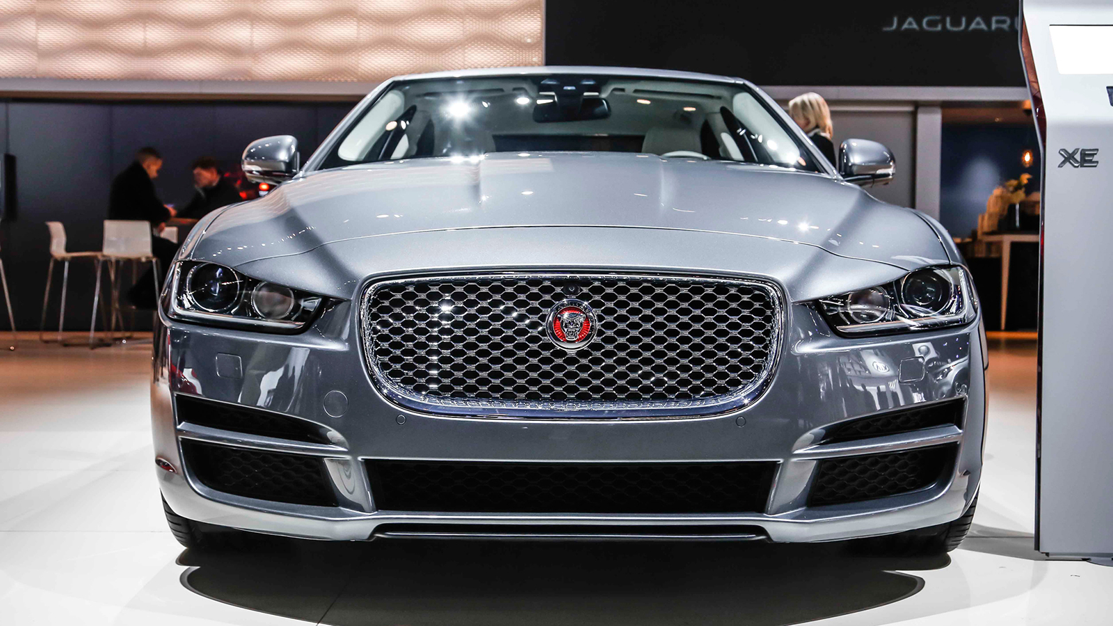 A silver car is parked in front of a building.