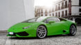 A green lamborghini parked on the side of a street.