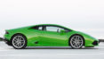 A green sports car is driving down the road.