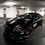 A black car parked in a parking garage.