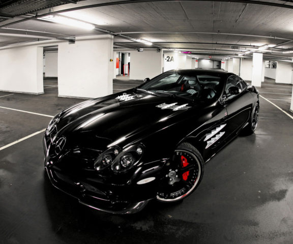 A black car parked in a parking garage.