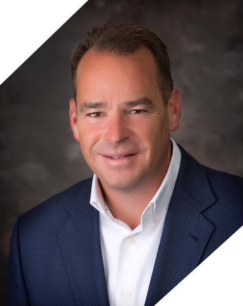 A man in a suit and tie smiling for the camera.